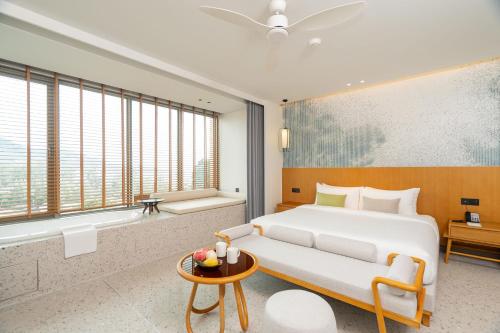 a hotel room with a bed and a bathtub and a bedroom at Wyndham Garden Phuket Kamala in Kamala Beach