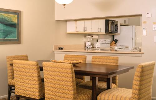 a kitchen and dining room with a table and chairs at Paniolo Greens Resort in Waikoloa