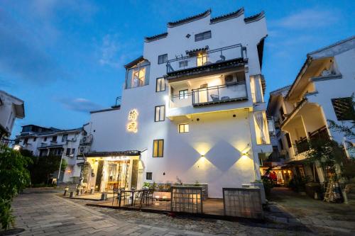 a white building with lights on the side of it at The Lu Village Retreat in Guilin
