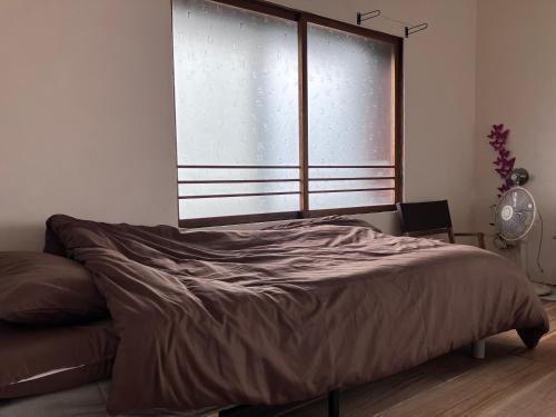 Ένα ή περισσότερα κρεβάτια σε δωμάτιο στο MOTORYOKAN Guesthouse & Cafe