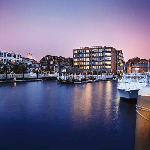 a boat is docked in a river with buildings at Club Wyndham Inn on the Harbor in Newport
