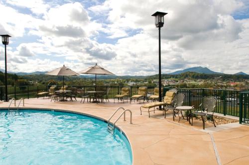a patio with a pool and tables and chairs at Club Wyndham Smoky Mountains in Pigeon Forge