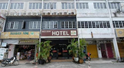 a hotel with plants in front of a building at OYO 1190 Nice Stay hotel in Raub