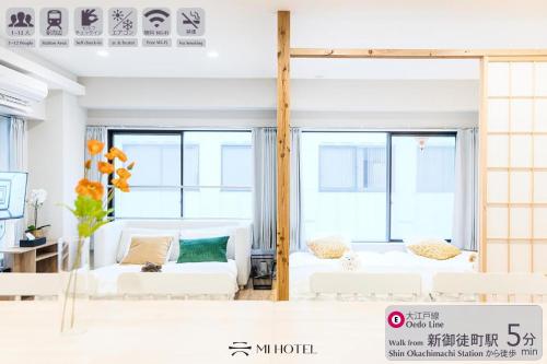 a living room with white furniture and large windows at Mi-HOTEL UENO in Tokyo
