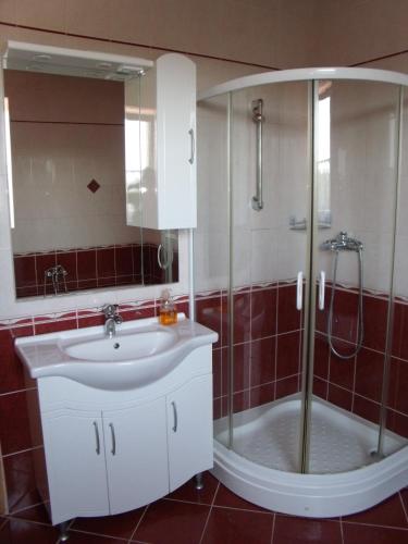 a bathroom with a sink and a shower at Viola Vendégház in Kehidakustány