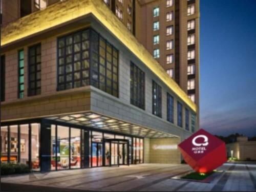 a building with a sign in front of it at Q Hotel Shanghai Pudong in Shanghai
