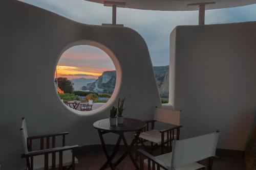 a room with a table and chairs and a round window at Hotel Chiaia Di Luna in Ponza