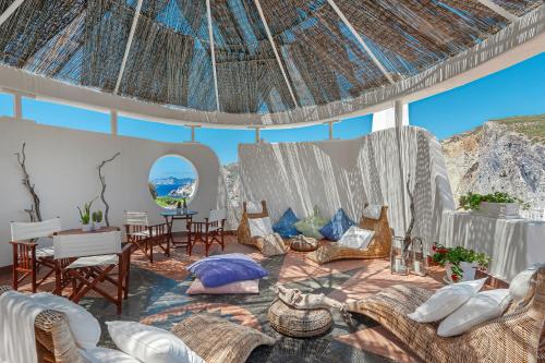 a room with couches and chairs and a view of the ocean at Hotel Chiaia Di Luna in Ponza