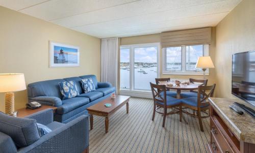 a living room with a blue couch and a table at Club Wyndham Inn on Long Wharf in Newport