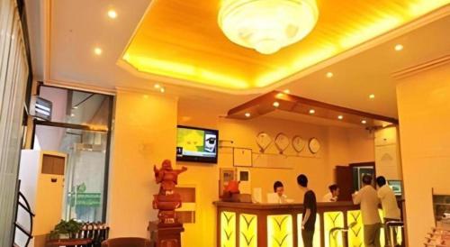 a living room with people sitting at a bar at GreenTree Inn Zhangjiakou Xuanhua Bus Station Shell Hotel in Zhangjiakou
