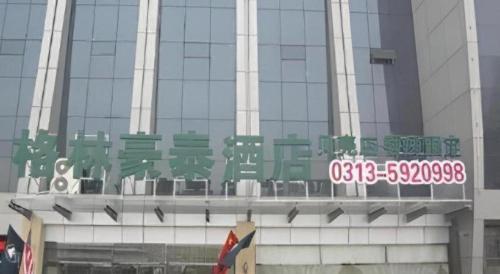 a building with a sign on the side of it at GreenTree Inn Zhangjiakou Xuanhua Bus Station Shell Hotel in Zhangjiakou