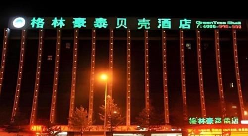 a building with chinese writing on it at night at GreenTree Inn Zhangjiakou Xuanhua Bus Station Shell Hotel in Zhangjiakou