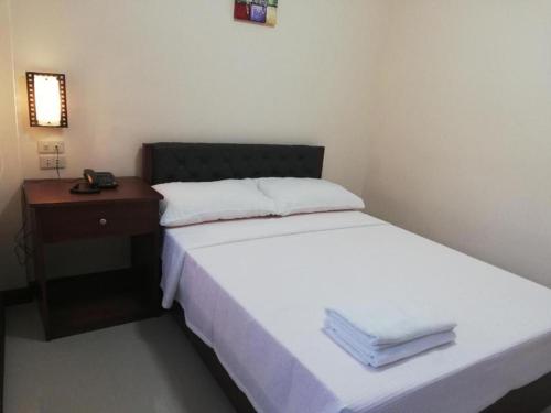 a small bedroom with a bed and a night stand at Sabine's Place in Masbate