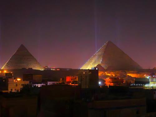 a view of the pyramids of giza at night at Pyramids Grand View Hotel in Cairo