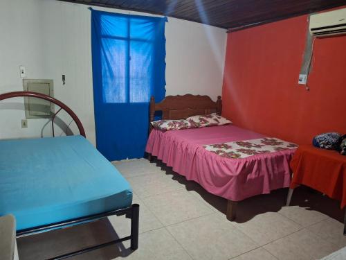 ein Schlafzimmer mit einem Bett und einer blau-roten Wand in der Unterkunft Aconchego benevides Barcelona in Benevides