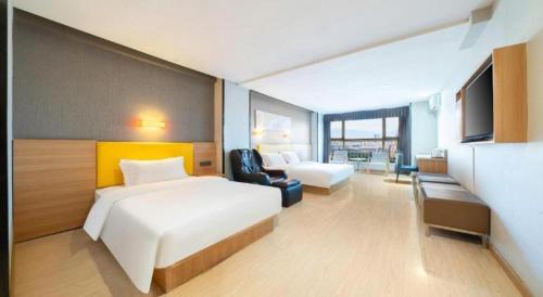 a hotel room with a bed and a couch and a chair at 7 Days Premium Xi'an Dayan Tower Xiaozhai Metro Station in Xi'an