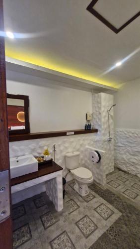 a bathroom with a toilet and a sink and a tub at Chunut House Resort in Phi Phi Islands