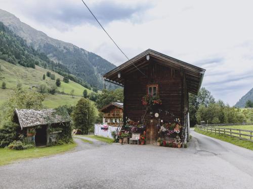 a small house with flowers on the side of a road at Apartment in Fusch an der Glocknerstraße in nature in Fusch an der Glocknerstraße