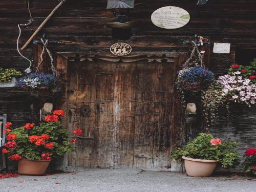 an old wooden door with flowers on it at Apartment in Fusch an der Glocknerstraße in nature in Fusch an der Glocknerstraße