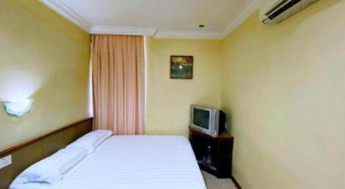 a hotel room with a bed and a tv at OYO 89958 Hotel Umimas in Lahad Datu