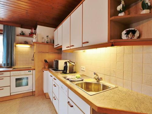 a kitchen with a sink and a microwave at Apartment in Niedernsill near Ski Slopes in Niedernsill