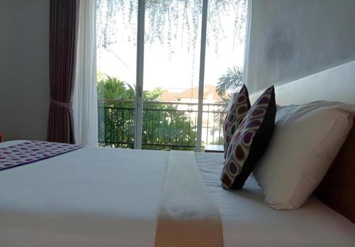 a bedroom with a bed with a large window at MANDARI HOTEL SINGARAJA in Ubud