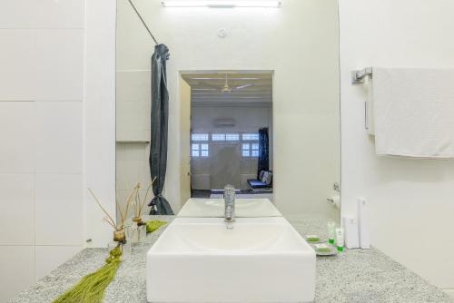 a bathroom with a white sink and a mirror at Itsy Hotels Red Lotus Heritage, Promenade Beach in Puducherry