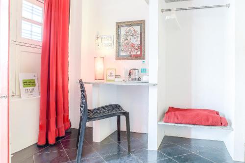 a room with a chair and a red curtain at Itsy Hotels Red Lotus Heritage, Promenade Beach in Puducherry