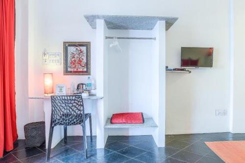 a room with a chair and a desk with a red pillow at Itsy Hotels Red Lotus Heritage, Promenade Beach in Puducherry