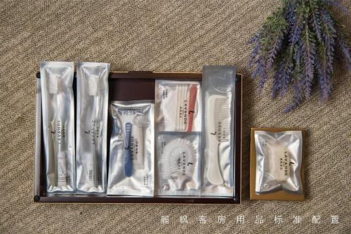a wooden box filled with toothbrushes and other brushes at Lavande Hotels Dalian Software Park University of Technology in Dalian