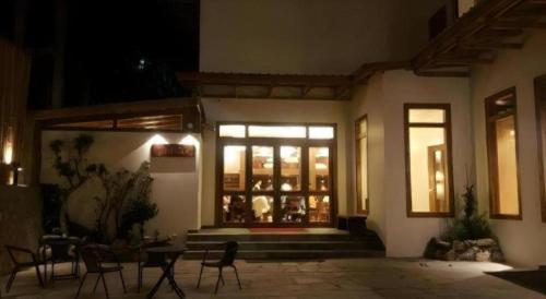 a building with chairs and tables in front of a window at The Pema by Realm in Thimphu
