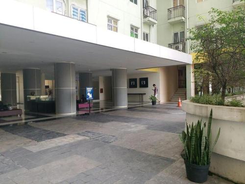 a large building with a person standing in front of it at OYO Living 3091 Apt The Suites Metro By Ananda in Bandung