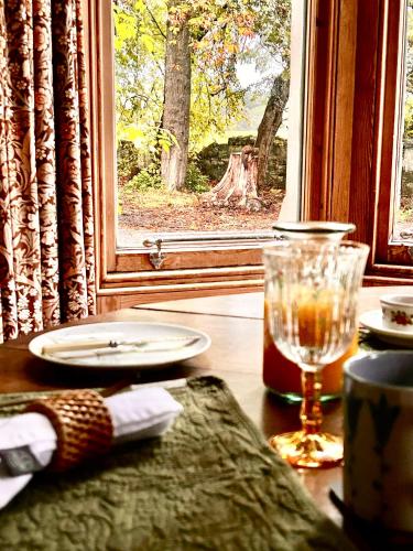 a table with a glass on a table with a window at Clashmore House in Dornoch
