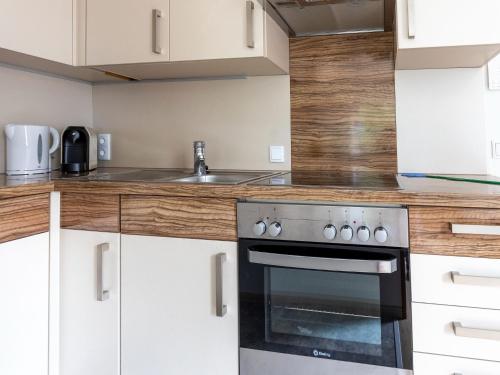 a kitchen with a stove and a sink at Gailtaler apartment at an excursion location in Kötschach