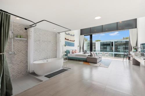 a bathroom with a tub and a shower and a couch at Pool Access Spacious Townhouse and Kids Slide in Koh Samui