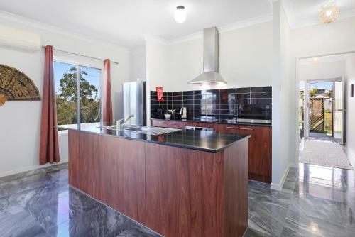 a kitchen with a large wooden island in the middle at Gold Coast Family Stay - 4BR Near Theme Parks in Gold Coast