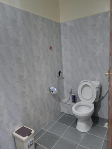 a bathroom with a toilet and a trash can at Studio Executive Serenity in Eldoret in Eldoret