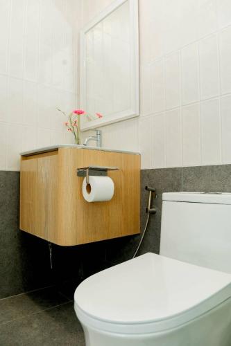 a bathroom with a toilet and a sink and a mirror at Patcharapon Resort in Ban Pong