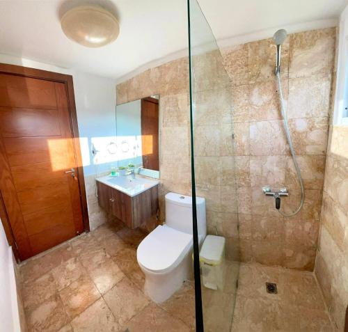 a bathroom with a toilet and a shower and a sink at Residencial la ensenada, on Playa Nueva Romana in Boca del Soco