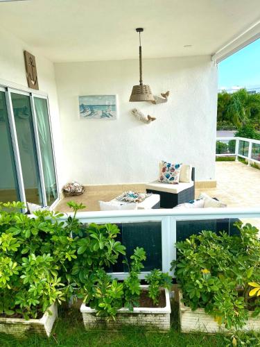 a living room with a couch and some plants at Residencial la ensenada, on Playa Nueva Romana in Boca del Soco