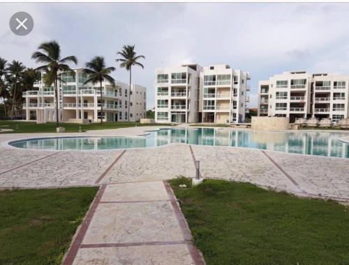 a swimming pool in front of some apartment buildings at Residencial la ensenada, on Playa Nueva Romana in Boca del Soco
