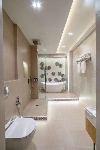 a bathroom with a tub and a toilet and a sink at Kamil Palace in Khiva