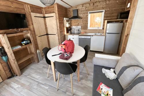 a small room with a table and a kitchen at Epicéa Lodge Hôtel et Camping in Pralognan-la-Vanoise