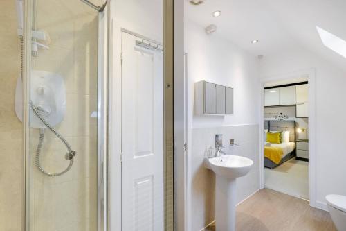 a white bathroom with a sink and a shower at 6 Bedroom 3 Bathroom House in Bicester Village in Bicester