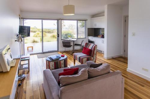a living room with a couch and a dining room at Eagle Peaks at Freycinet in Coles Bay
