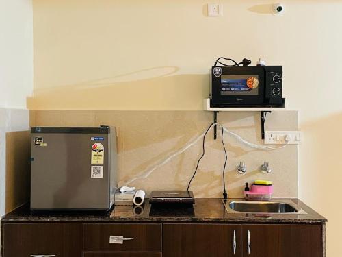 a kitchen with a counter with a microwave and a sink at Zivo Stays, Studio Apartments, Jubilee Hills in Hyderabad