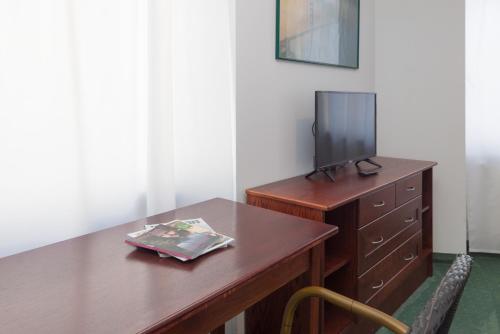 a room with a wooden desk with a tv on it at Pension San Francisco in Vienna