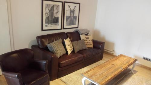 a brown leather couch and a coffee table in a living room at Stadtblick in Salzburg