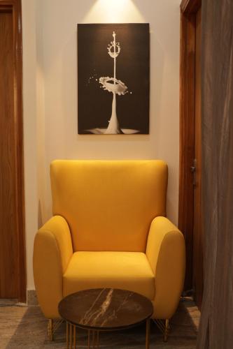 a yellow chair and a table in a room at Let'stay- Noida Sec-112 in Noida
