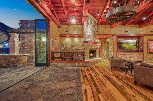 a large living room with a stone fireplace in a house at Castle On Black Mountain breathtaking panoramic views and outdoor entertainment in Cave Creek